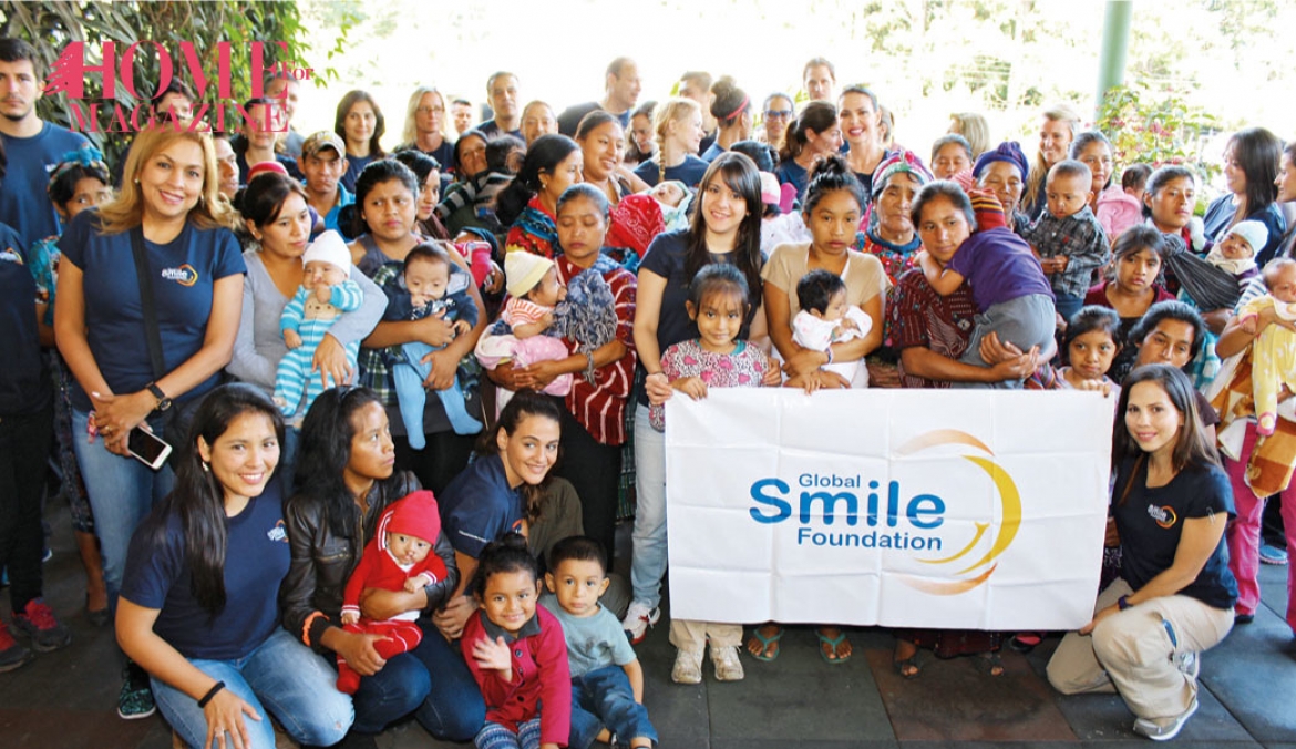 a group of people and kids holding a flag with Global smile foundation