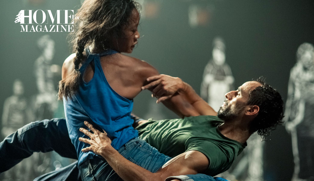 a women with a blue shirt and a man with a green shirt with their hands dancing while the man bending