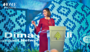 Woman speaker in red on stage with blue background