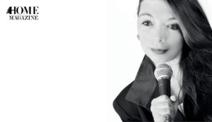 Girl in black shirt and hair to one side holding microphone in hand