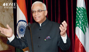 Man wearing eyeglasses and black jacket raising his hands with two red and white flags behind him