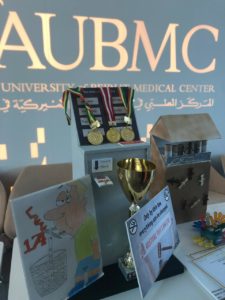 AUBMC logo with cards and medals