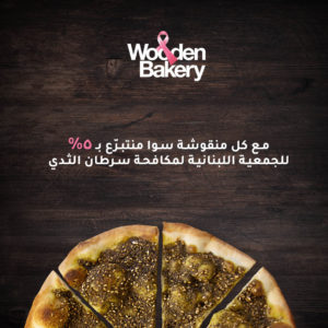 Mankoushe with thyme cut into 4 slices with words written in white and pink in arabic and english
