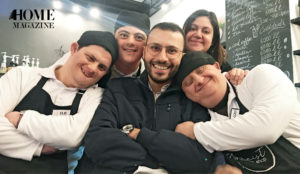Smiling man surrounded by kids with special needs