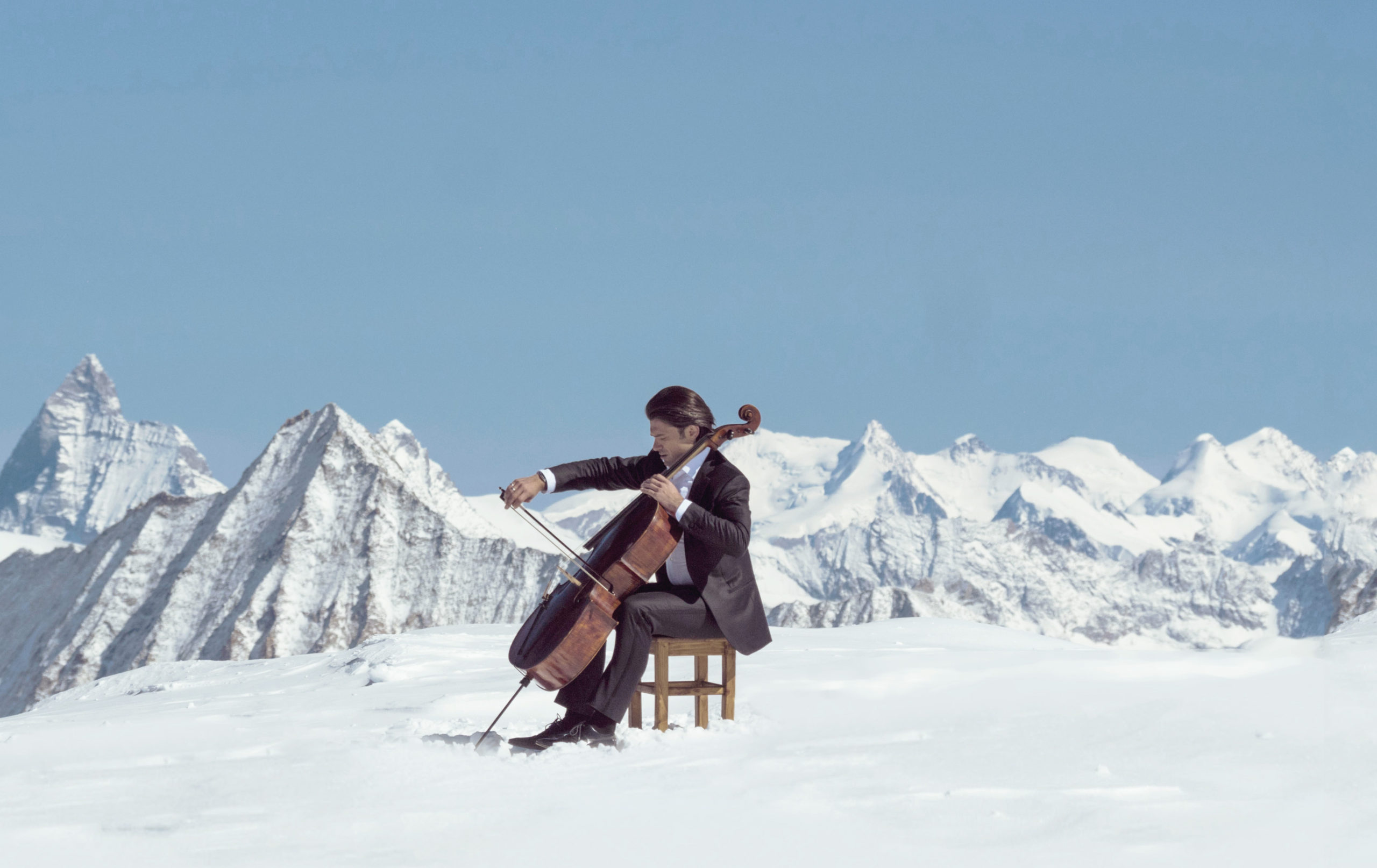 snow view with a person sitting with his celio on a chair