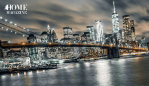 A bridge crossing waters amidst lightened buildings
