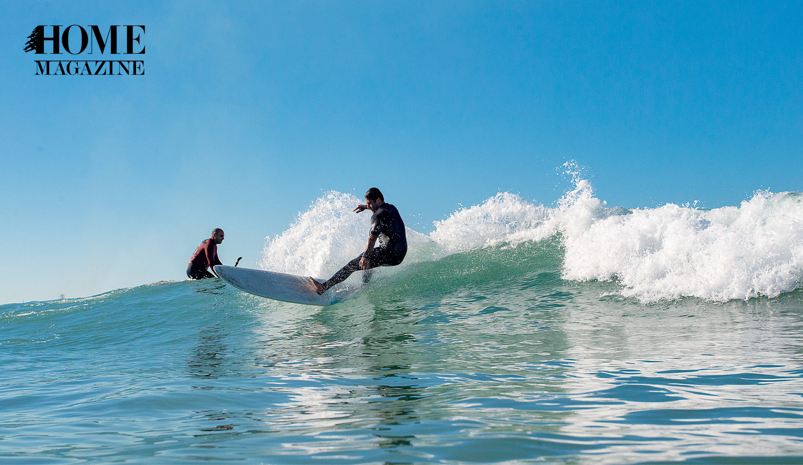 Two men riding waves of sea