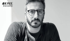 Man with eyeglasses wearing a black t-shirt with tattoos on his sleeves