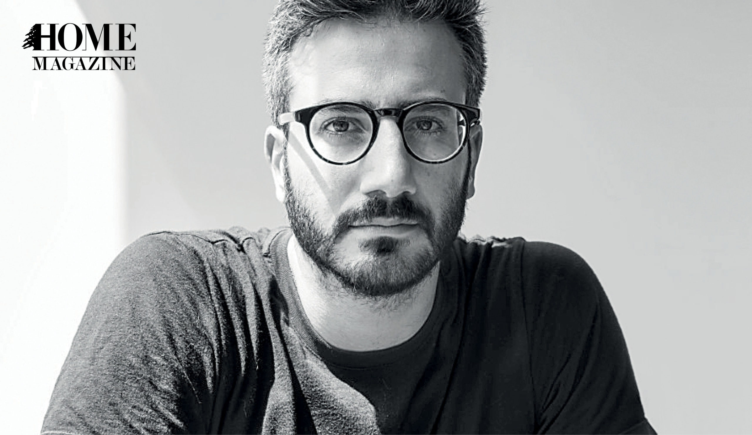 Man with eyeglasses wearing a black t-shirt with tattoos on his sleeves