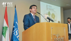 Man wearing suit and eyeglasses giving speech on microphone stand