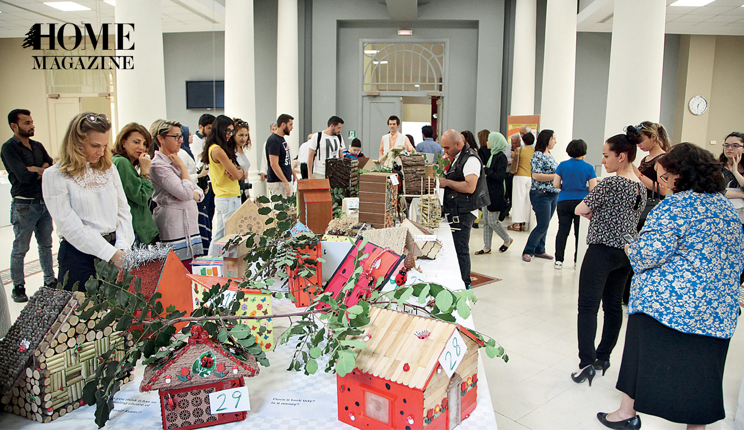 Group of people looking at wood made objects with green leaves