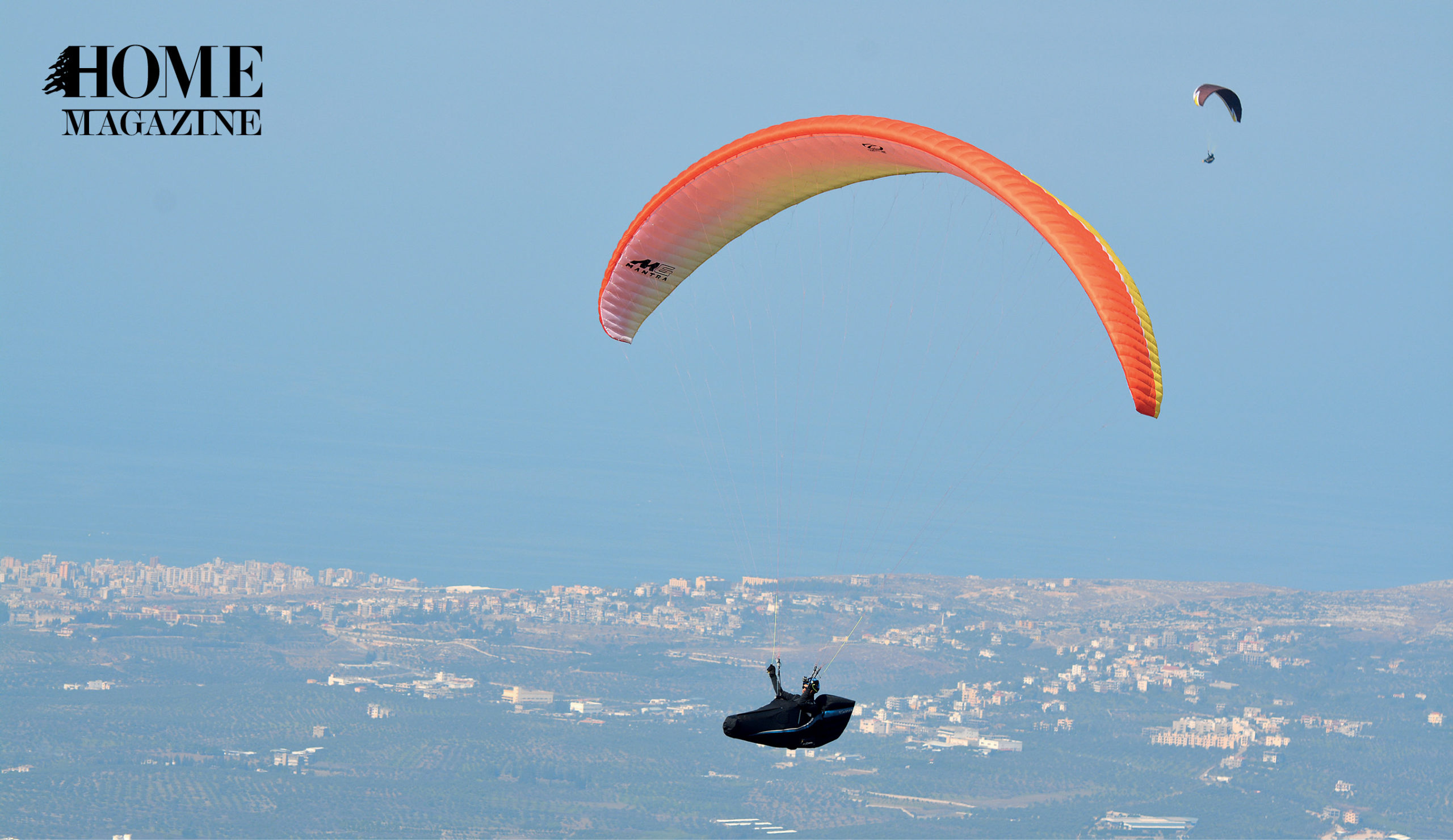 Two parachutes flying amidst blue sky