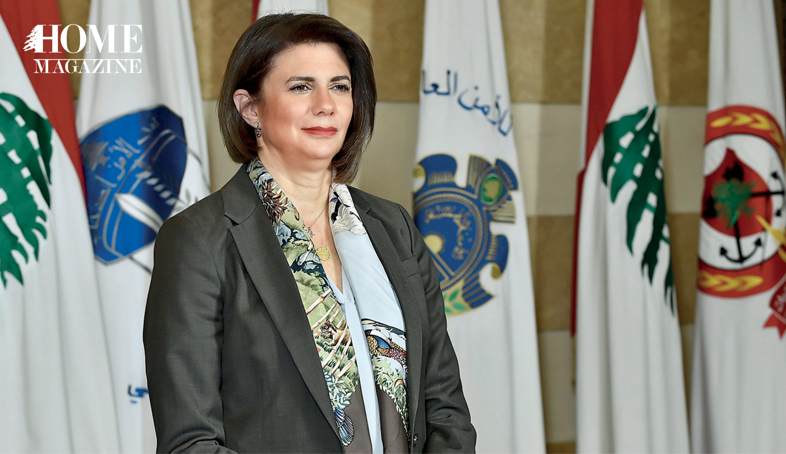 Woman in suit standing in front of flags