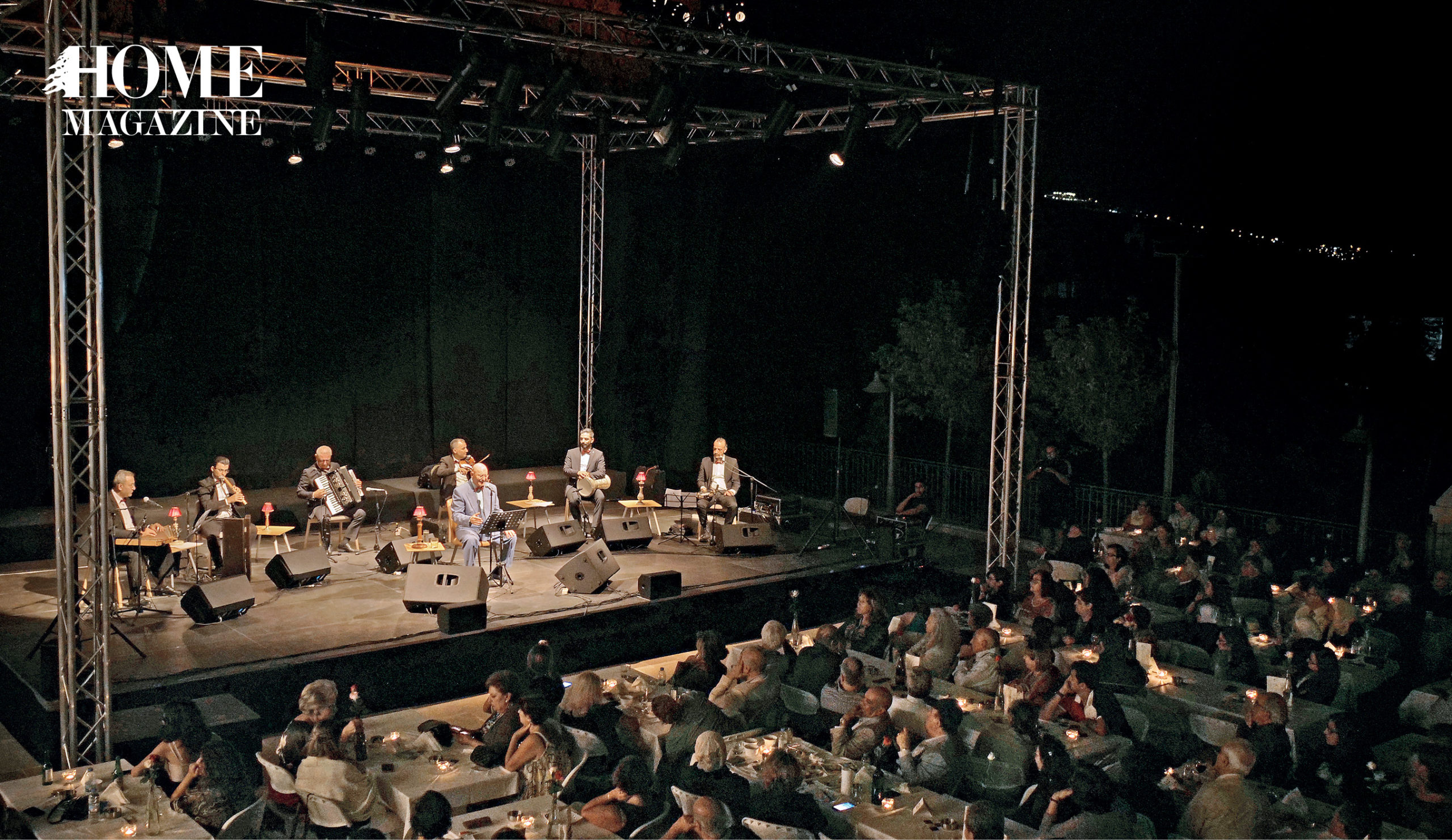 Band performing on stage at night with seated crowd