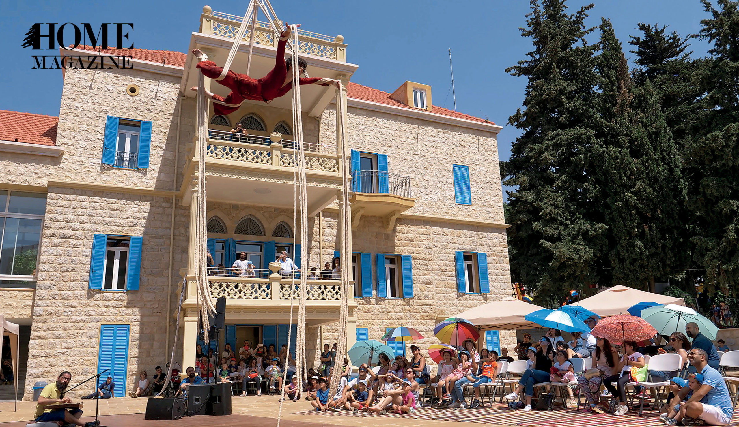 Man performing on ropes in front of house and crowd
