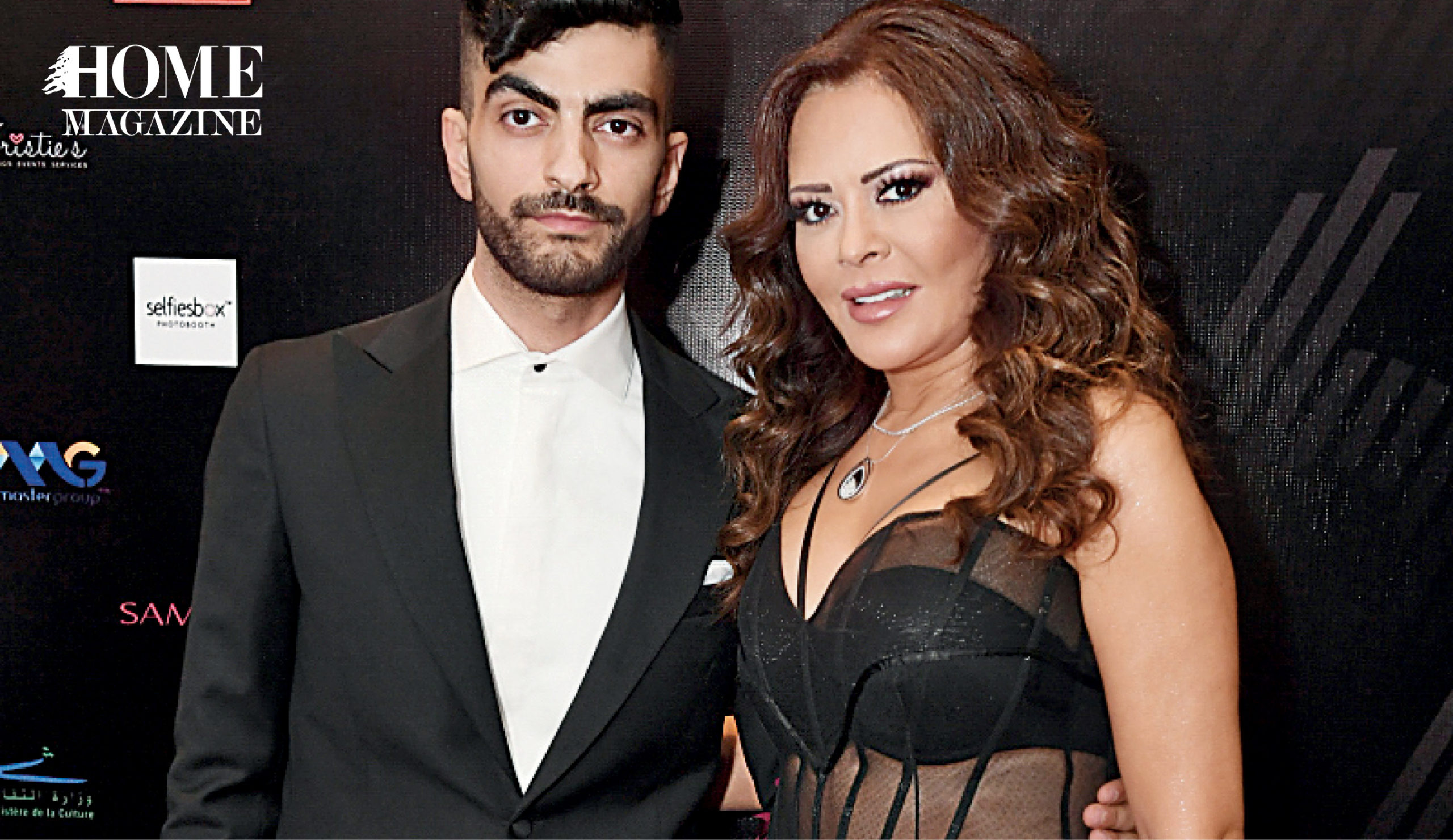 Woman in black dress standing next to man in black suit