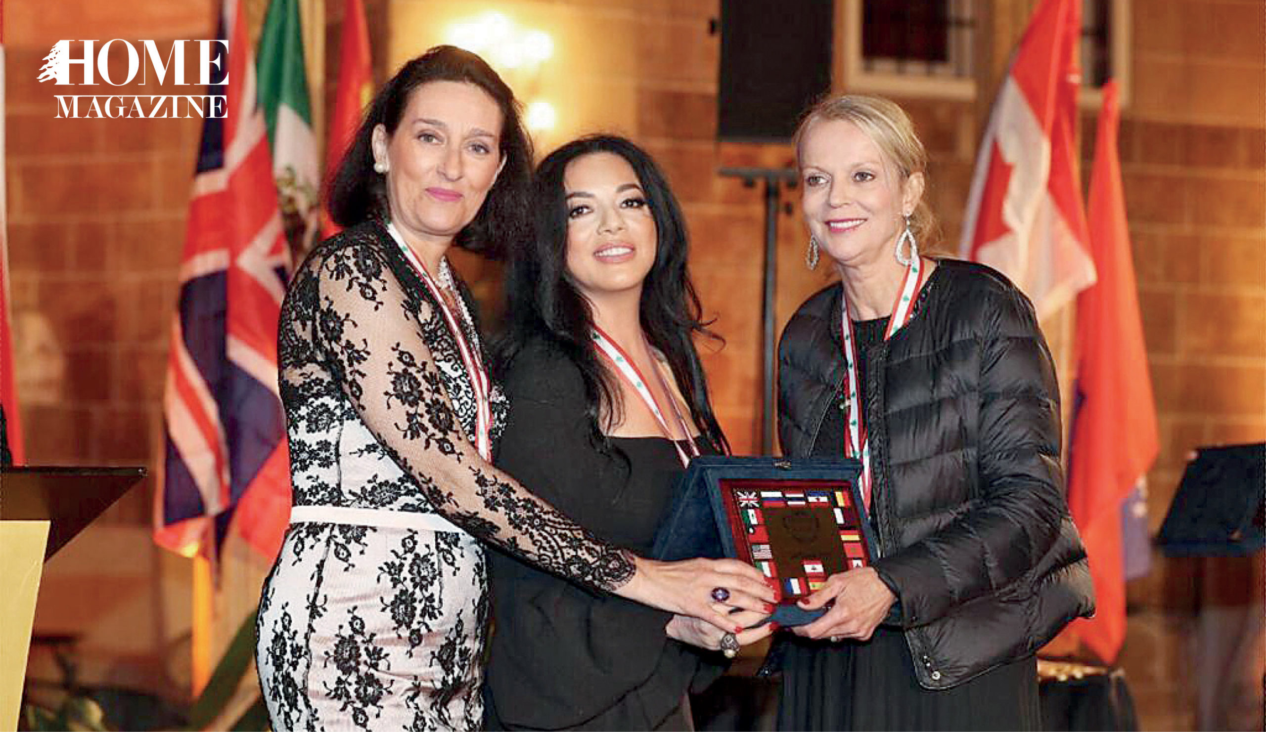 Three woman holding a trophy on stage