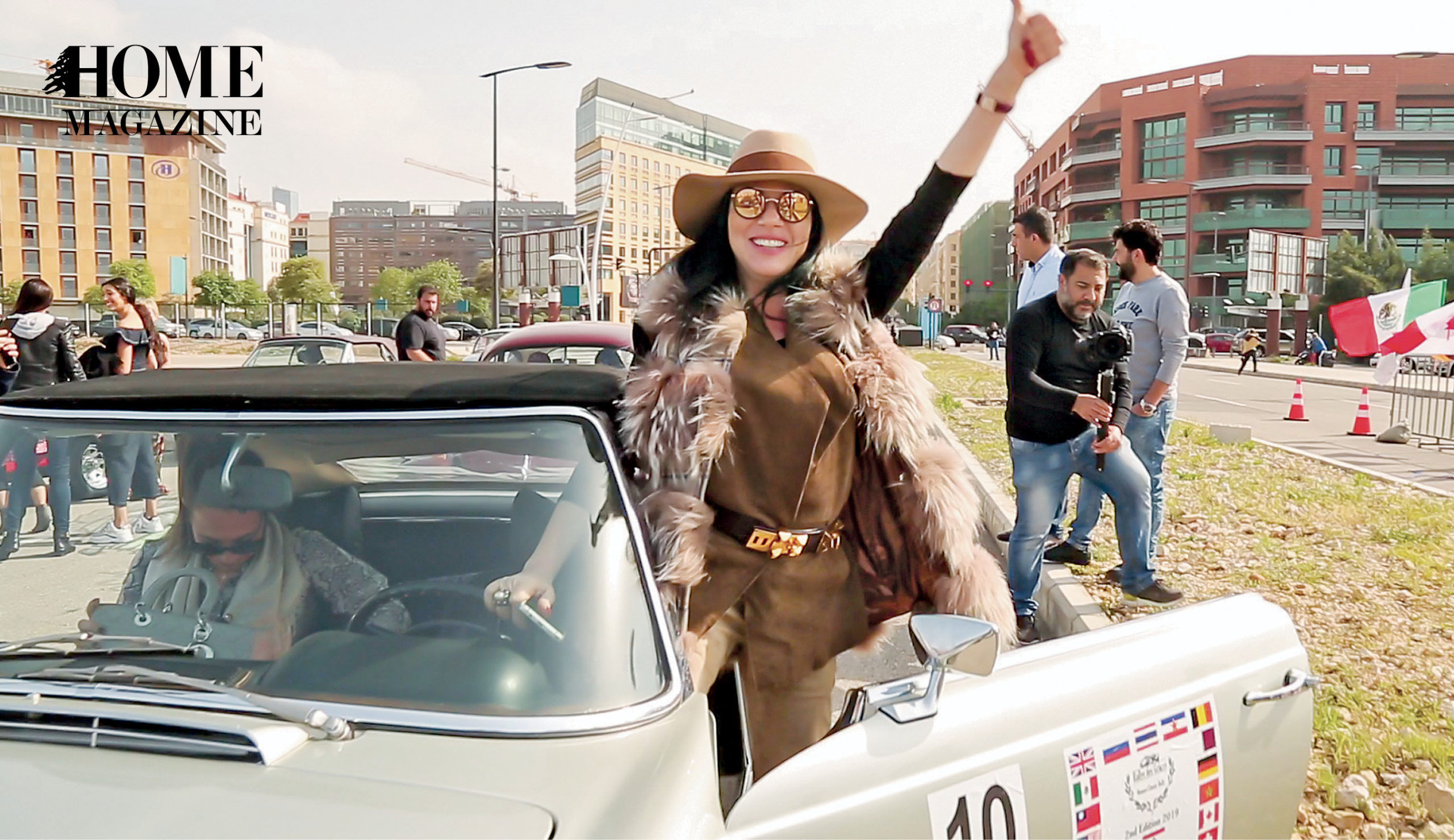 A woman stepping outside a car with her thumbs up